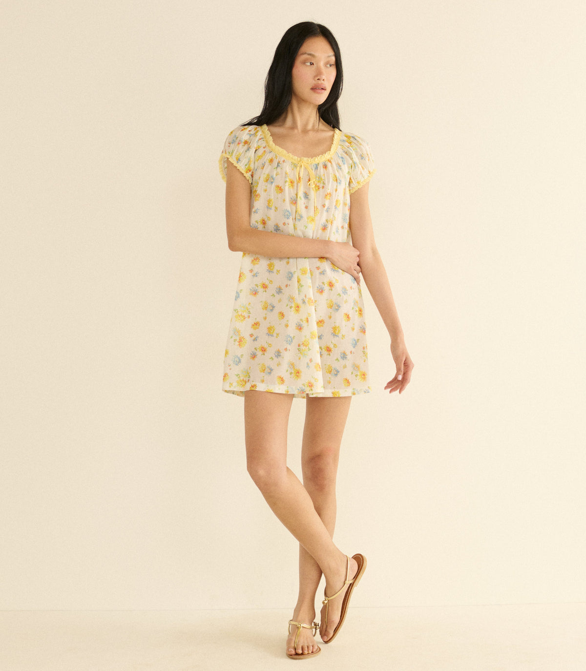 Woman wearing a white floral dress on a beige background